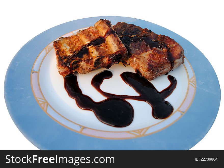 Grilled pork ribs whit sauce in a white dish