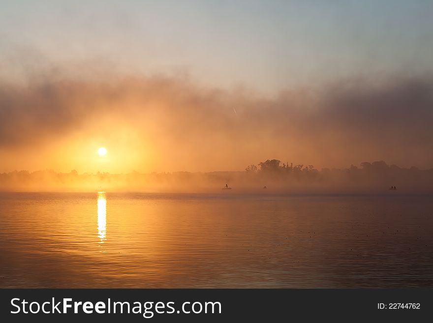 Fisherman's silhouette fishing at sunrise in lake. Fisherman's silhouette fishing at sunrise in lake