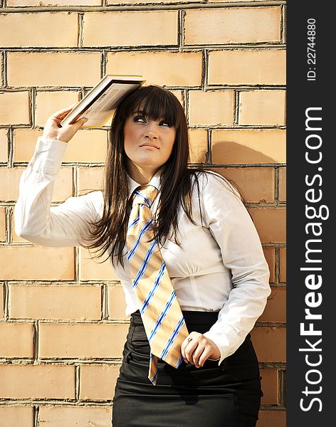 Beautiful girl near the wall of red bricks with a book. Beautiful girl near the wall of red bricks with a book