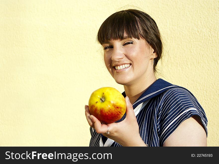 A beautiful girl  of the wall keeps apple