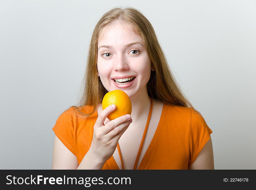 Cute blonde girl with an orange in her hand. Cute blonde girl with an orange in her hand.