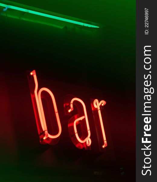 Red and green neon bar on brown signboard. Red and green neon bar on brown signboard