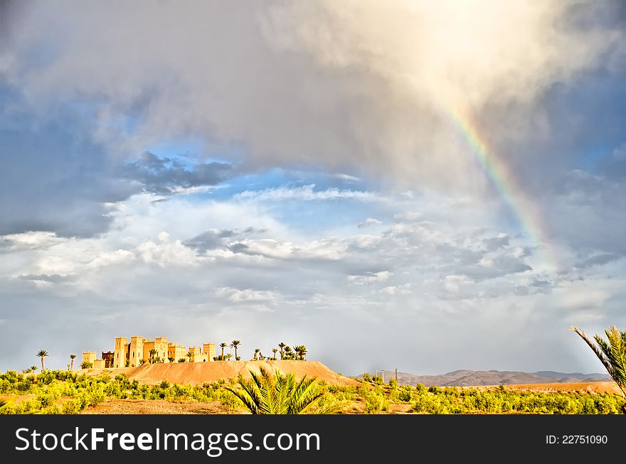 A rainbow over a romantic sky in the moroccan desert with a kasbah (fort). A rainbow over a romantic sky in the moroccan desert with a kasbah (fort)