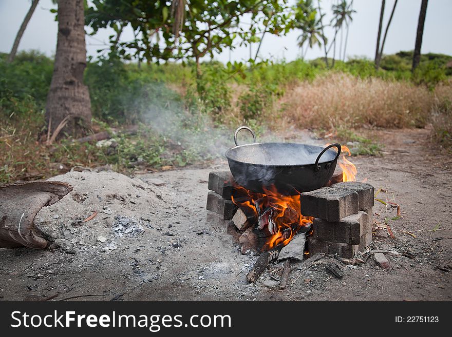 Cooking something in dirty pan on open fire with fire and smoke. Cooking something in dirty pan on open fire with fire and smoke