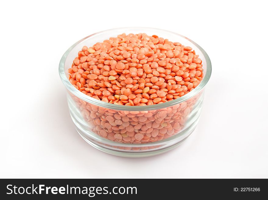 Collection of dried pink or red lentils in transparent glass bowl