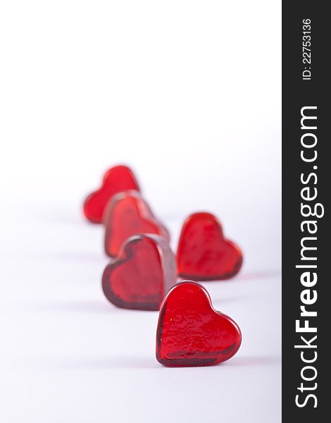 Five Glass hearts in portrait format with shallow depth of field.