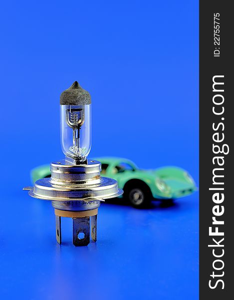 Car halogen bulb stands in the foreground and on the back of the car model. Car halogen bulb stands in the foreground and on the back of the car model