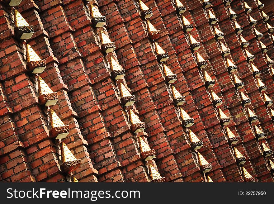 Brick wall with metal decoration of gold colour