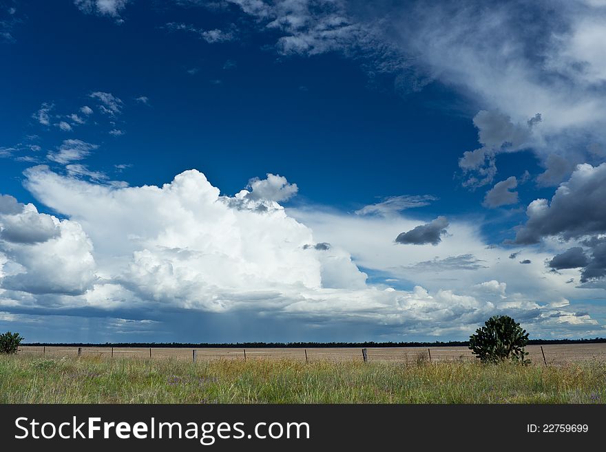 Blue sky with clouds over a field in the country. Blue sky with clouds over a field in the country