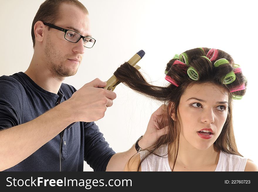 Man arranging model hair with tool. Man arranging model hair with tool