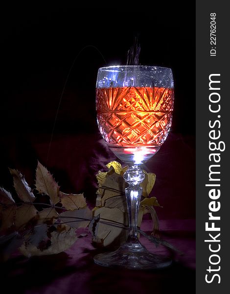 Crystal  wine glass with pouring wine and fall background