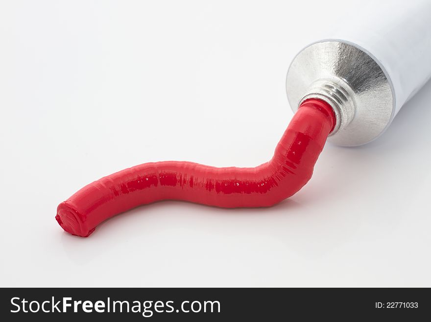 Red paint tube on a white background