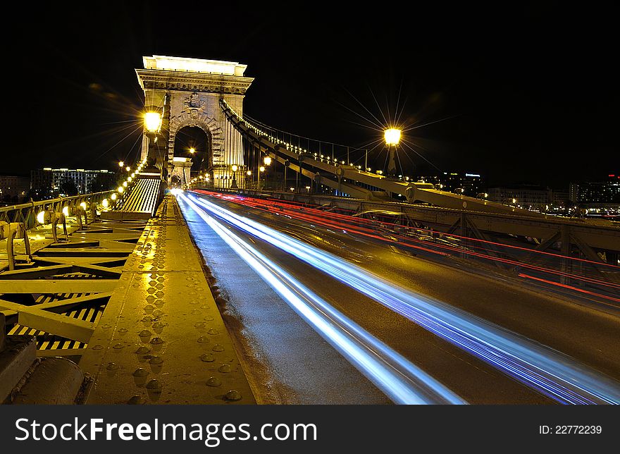 Car lights on exposure over the Chain Bridge in Budapest. Car lights on exposure over the Chain Bridge in Budapest