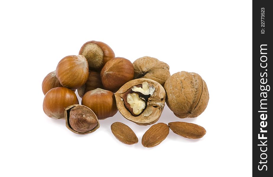 Walnut, filbert, almond by a mineral deposit on a white background. Walnut, filbert, almond by a mineral deposit on a white background