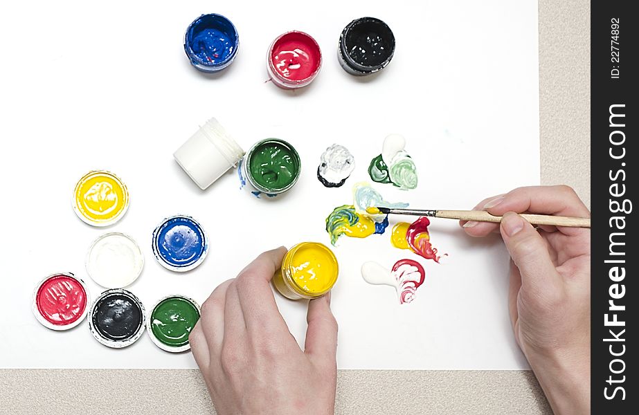 Artist mixes paint a different color on paper. Artist mixes paint a different color on paper