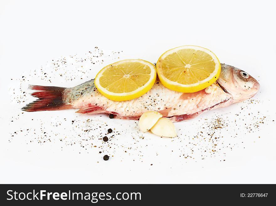 Raw fish with lemon on white background