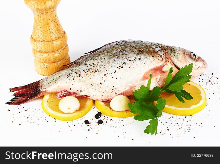 Raw fish with lemon and parsley on white background