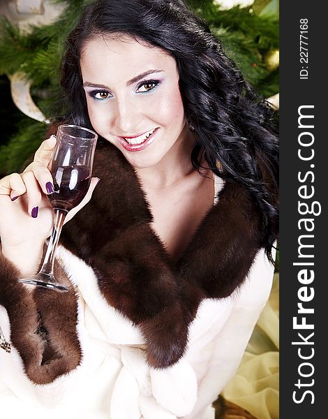 Beautiful young woman on santa hat drinking wine