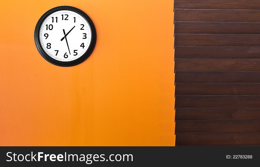 Wall clock on orange wall in afternoon. Wall clock on orange wall in afternoon