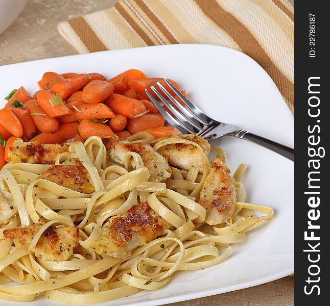 Chicken strips on top of noodles with carrots. Chicken strips on top of noodles with carrots