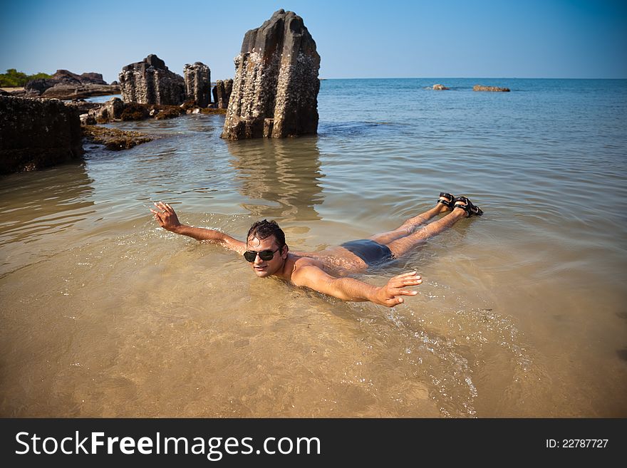 Indian man swimming at ocean beach