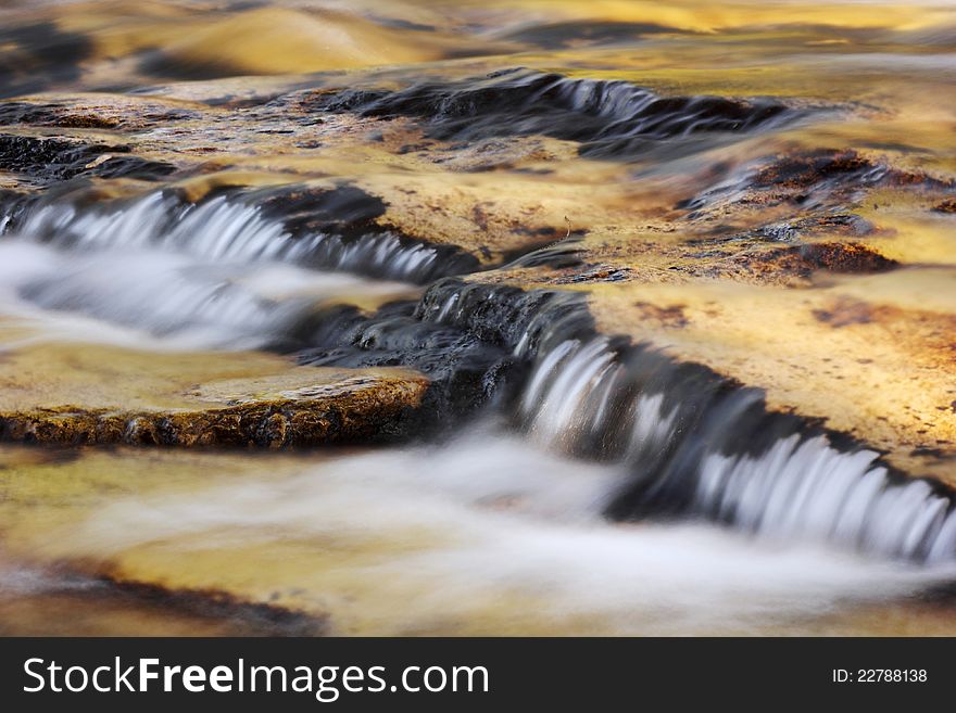 A beautiful small and crispy clear stream flowing in late afternoon sun. A beautiful small and crispy clear stream flowing in late afternoon sun