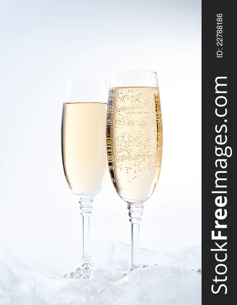 Two glasses of champagne on white fabric