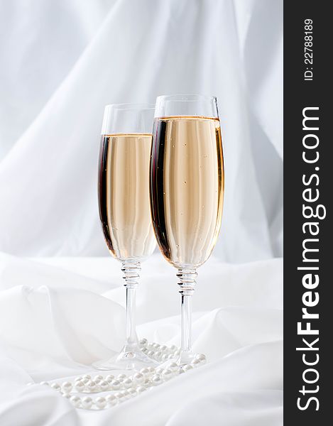 Two glasses of champagne on white fabric