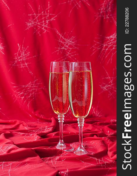 Two glasses of champagne on red fabric