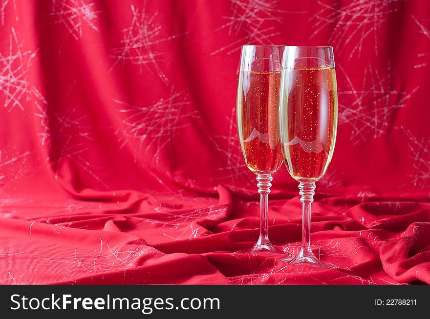Two glasses of champagne on red fabric