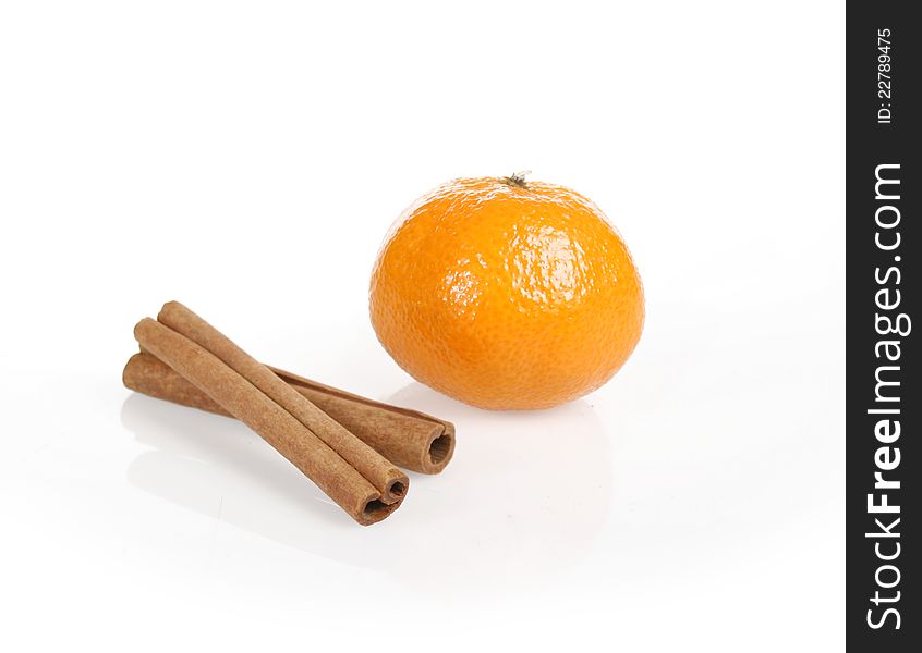 Orange fruit segment and cinnamon sticks on white background.