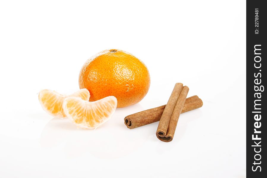 Tangerine and cinnamon sticks on white background.