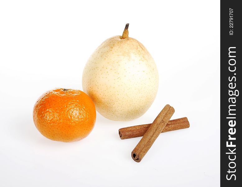 Tangerine, pear and cinnamon sticks on white background