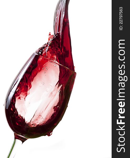 Red wine pouring into glass, isolated on white background