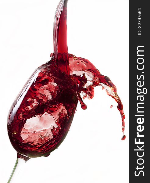 Red wine pouring into glass, isolated on white background