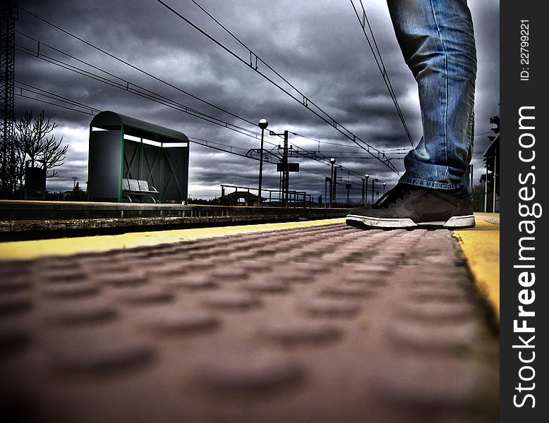 A man waiting the train in a dark evening