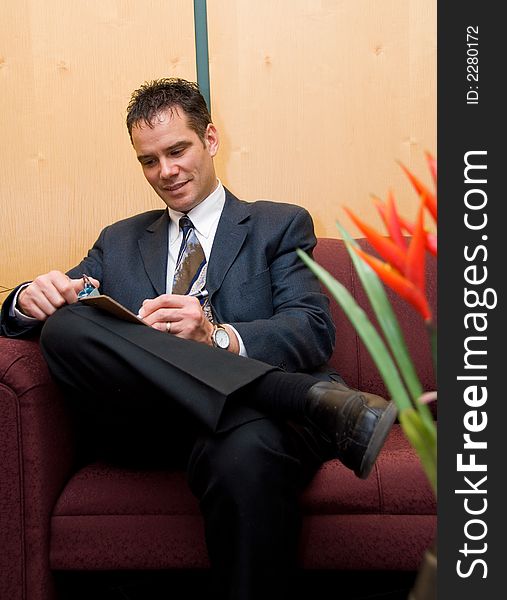 Business man taking notes in a reception area. Business man taking notes in a reception area