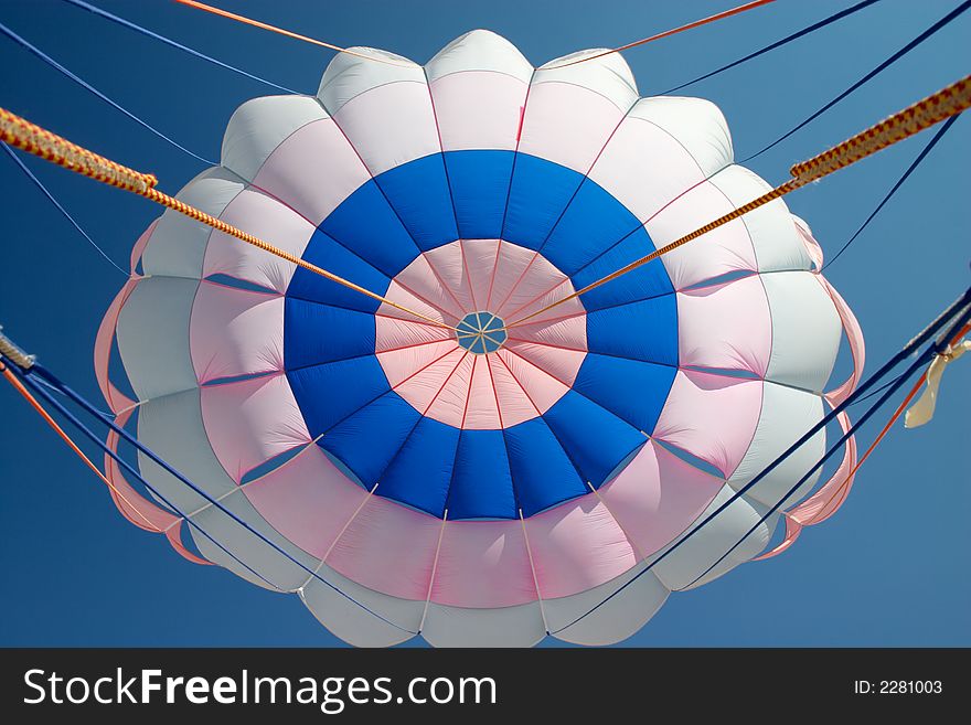 Bright parachute canopy in the blue sky