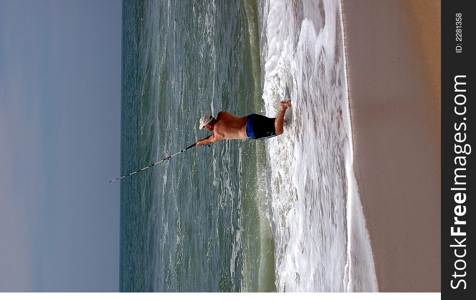 Man casting into the ocean on a warm summer day. Man casting into the ocean on a warm summer day