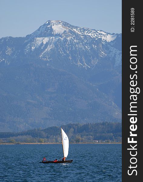 Sailing ship in the Alps lake at the morning