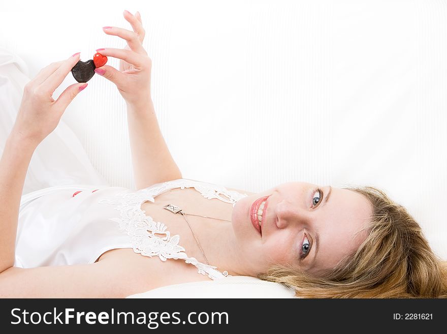 A blond women playing with red and black stone hearts. A blond women playing with red and black stone hearts