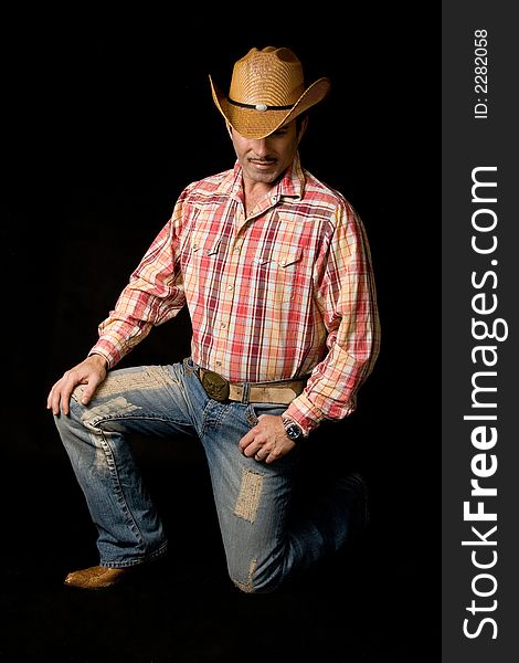 Adult cow boy looking down and posing for fashion shots. Adult cow boy looking down and posing for fashion shots
