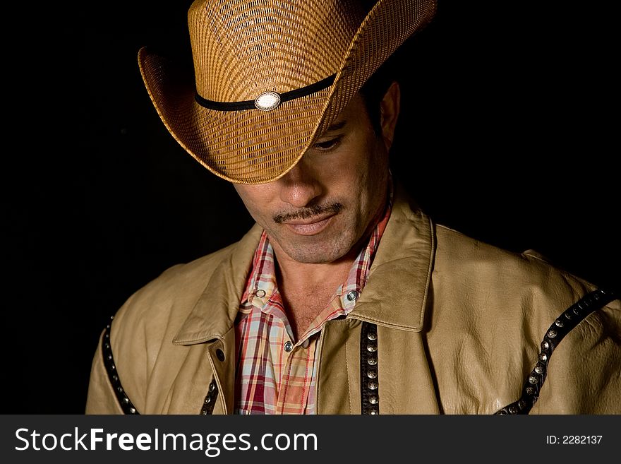 Adult cow boy looking down and posing for fashion shots. Adult cow boy looking down and posing for fashion shots