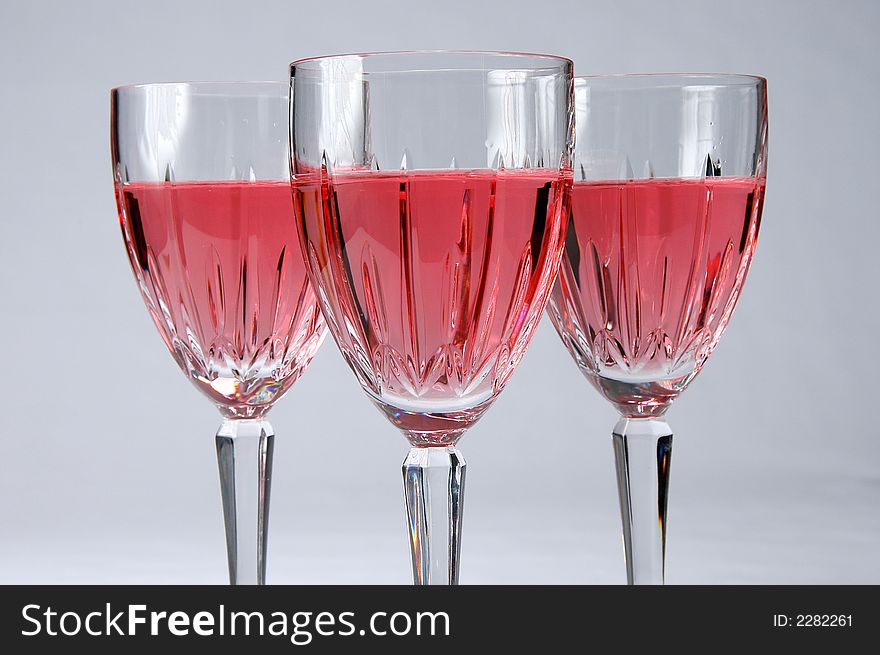 Close up of three zinfandel wine glasses over a neutral background. Close up of three zinfandel wine glasses over a neutral background