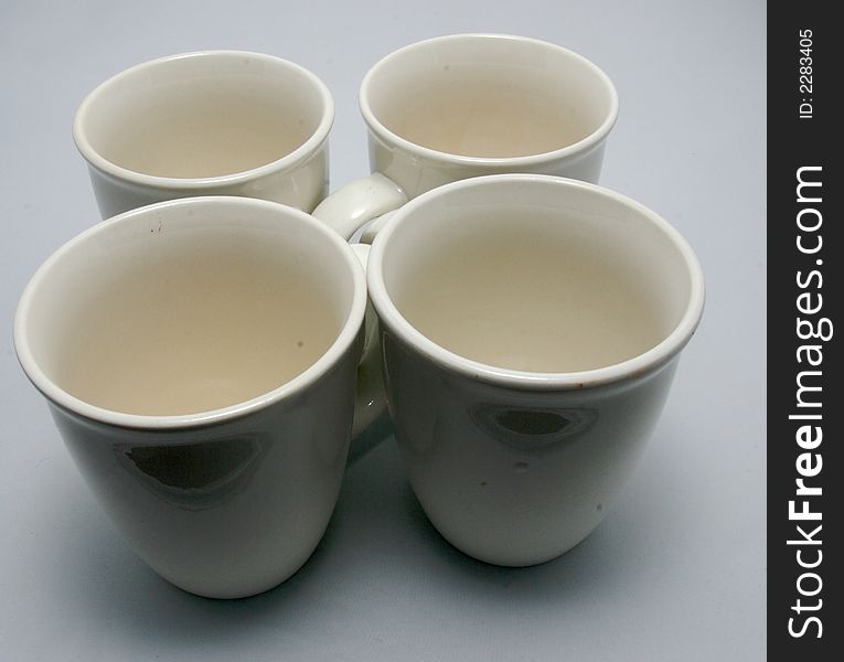 Four white drinking cups on a white background
