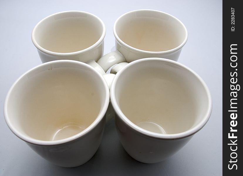 Four white drinking cups on a white bakcground