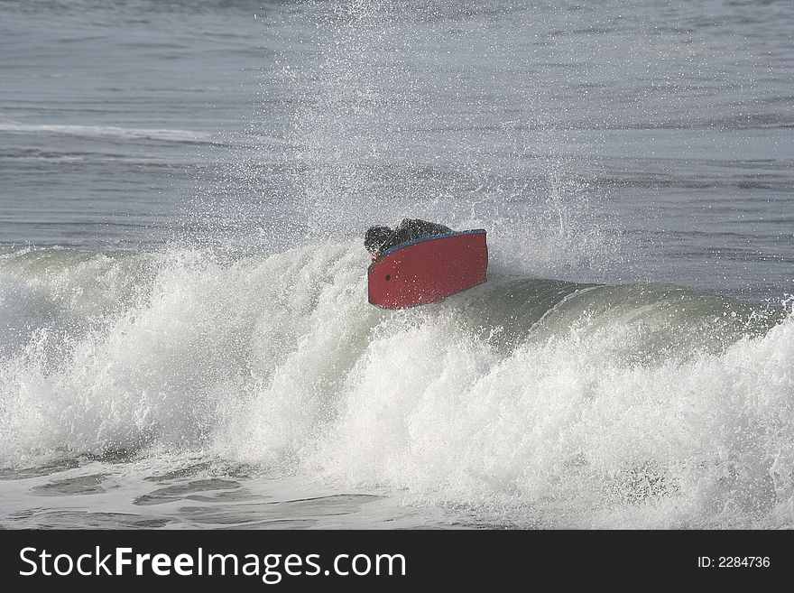 Photo of a bodyboarder on top of the wave