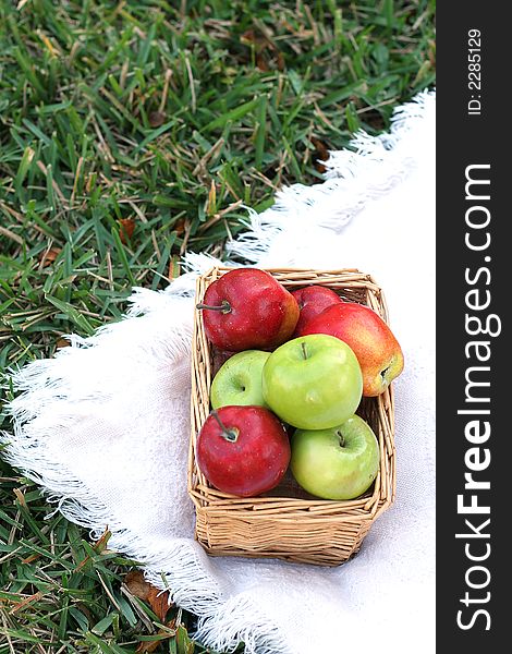 Apples in basket on grass