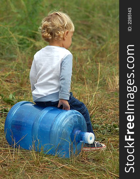 A young child playing with an empty water dispenser