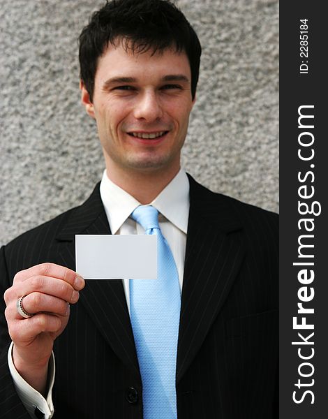 Businessman holds a blank card - add your own text. Focus on the card.